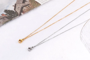 Detail of gold and silver layered necklaces with lobster clasps on a white background