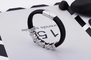Détail du bracelet en cuir tressé et chaîne de moto en acier inoxydable avec fermoir poli