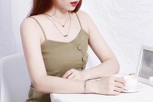 Model wearing silver double-layer infinity necklace, matching bracelet and ring set