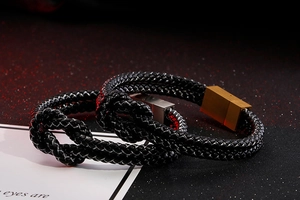 Detail of double-layer braided leather bracelet with magnetic knot clasp in gold and silver