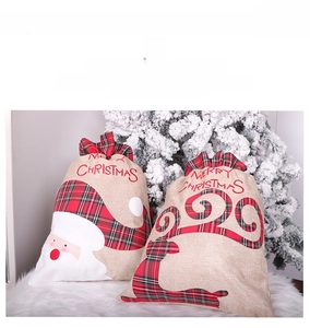 Detailed view of burlap Christmas gift bags with Santa and reindeer embroidery