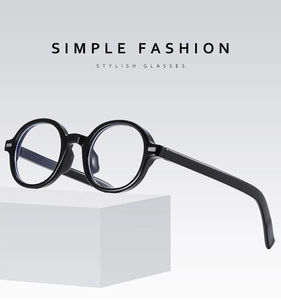 Detailed view of black round resin eyeglass frame on a geometric stone display pedestal