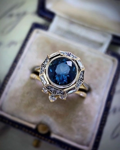 Macro shot of vintage gold ring with dark blue sapphire and diamonds in velvet box