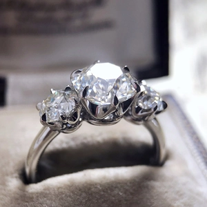 Three-stone white zircon ring with brilliant cut diamonds in a luxury velvet jewelry box