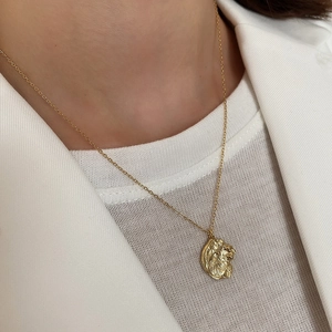 Close-up of a 925 silver golden lion head pendant necklace worn on a model