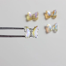 Macro shot of 3D iridescent opal butterfly nail art charms with crystal rhinestones