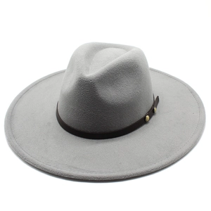 Detail of light gray wide brim fedora hat featuring brown leather band and gold metal studs