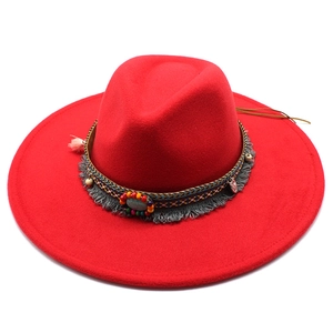 Close-up of red wool fedora with ethnic beaded band and grey tassel detail