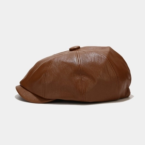 Detail of premium brown leather newsboy cap showing fine stitching and top button