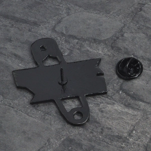 Macro shot of black metal badge back featuring a secure safety pin and butterfly clasp accessory