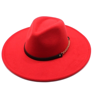 Detailed macro of the bright red wool fedora featuring a chic gold chain and black leather band