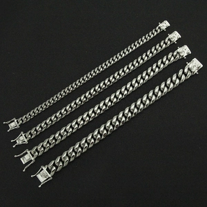 Bracelets gourmette en acier inoxydable poli en quatre largeurs sur fond noir sombre