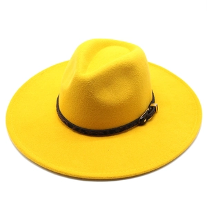 Detail of yellow wool felt fedora featuring a patterned band and gold metal buckle