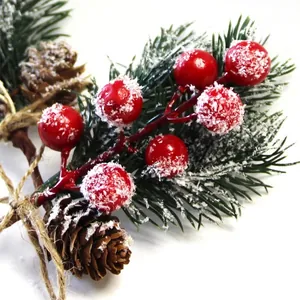 Christmas decoration featuring red berries, pine needles, and pinecones with fake snow