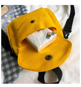 Top view of yellow canvas crossbody bag showing inner storage capacity with button closure