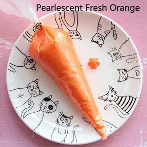 Close-up of pearlescent orange cream glue for DIY crafts in a white cat-themed plate