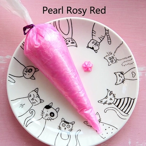 Close-up of pearlescent rose red cream glue paste in a squeeze bag for DIY crafts