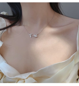 Detailed close-up of tulip flower pendant necklace with white opal and crystal leaf accent