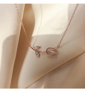 Macro shot of rose gold tulip necklace featuring opal flower bud and zircon leaves