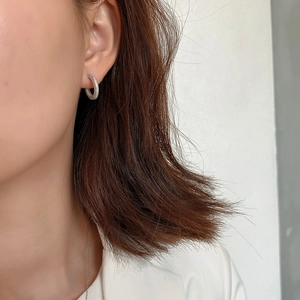 Close-up of minimalist 925 silver pave-set hoop earring with sparkling zirconia stones