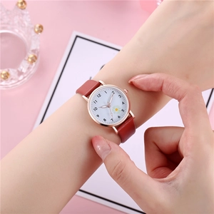 Dettaglio di un orologio da donna alla moda con quadrante bianco a margherita e cinturino