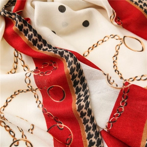 Dettaglio dei motivi a catena e leopardati su un morbido foulard in seta
