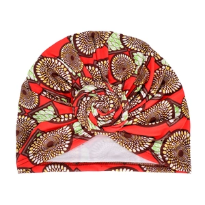 Detail of red African style snail turban hat with geometric patterns and twist knot