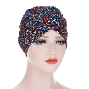 Detail of the navy blue ethnic print turban cap featuring a 3D fabric rose knot design