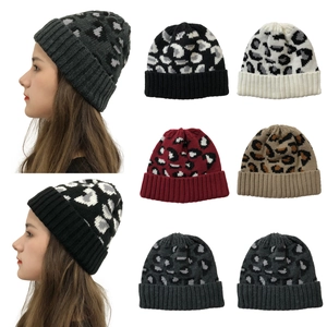 Detail view of leopard print knit beanies in various colors like khaki and dark grey