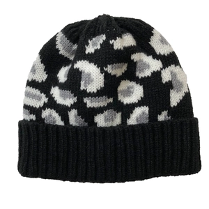 Detailed view of leopard print knit hat with white and grey patterns on black background