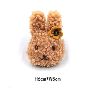 Detail eines Plüsch-Hasen-Accessoires mit gelber Häkelblume, Maße ca. 6 cm x 5 cm groß