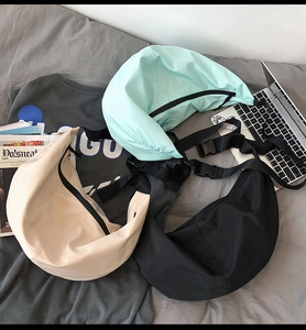 Detailed flat lay of nylon crescent bags in blue, beige, and black with strap buckles