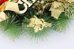 Détail du nœud doré et de l'ange sur une couronne de Noël en sapin vert artificiel