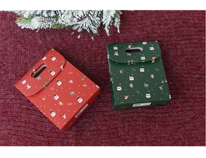 Close-up of red and green Christmas gift boxes with cartoon Santa and deer patterns