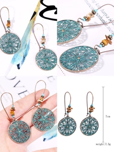 Macro view of bohemian bronze earrings with turquoise patina and beaded accents