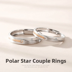 Close-up of matte silver sun and moon couple rings with rose gold shooting star detail