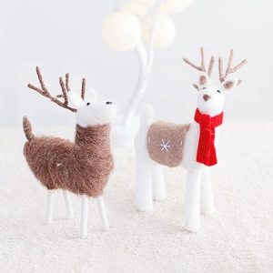 Handmade wool felt Christmas reindeer ornaments with red scarves on white carpet