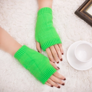Thick knitted neon green fingerless gloves for winter shown on a cozy white plush surface