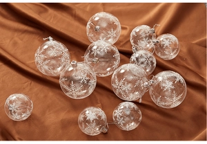 Macro view of transparent Christmas balls with white snowflake patterns on red silk