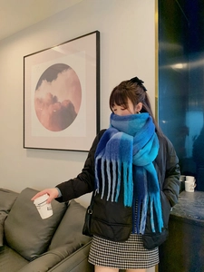Detailed close-up of blue gradient plaid scarf with thick fringe and soft texture