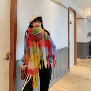 Close-up detail of soft faux cashmere scarf with rainbow plaid pattern and thick fringe