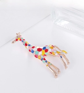 Detailed view of colorful enamel giraffe brooch with rose gold finish and artistic patterns