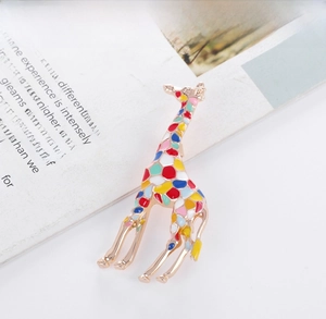 Detailed close-up of a colorful enamel giraffe brooch with gold-plated geometric patterns