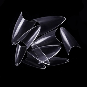 Macro detail of clear long stiletto nail tips with embossed size numbers on black background