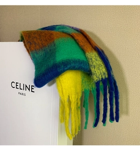 Close-up of thick checkered rainbow scarf with coarse tassels and mohair-like texture