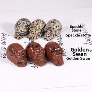 Macro detail of natural stone skulls in speckle stone and red golden swan finishes