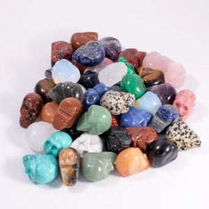 Macro shot of assorted colorful natural crystal skulls including amethyst and tiger eye
