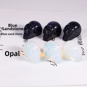 Detail of hand-carved skull figurines in blue goldstone and white opal gemstone textures