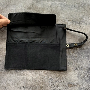 Detail van canvas horlogeband opbergtas met meerdere vakken en handige drukknoopsluiting.