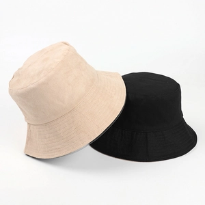 Close-up of beige and black suede bucket hats with reinforced stitching detail
